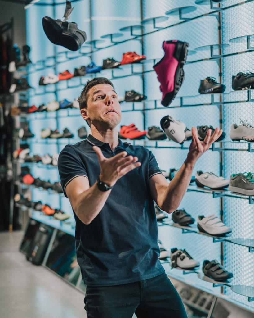 Guillaume jongle avec des chaussures de vélo dans le magasin Primeau Vélo